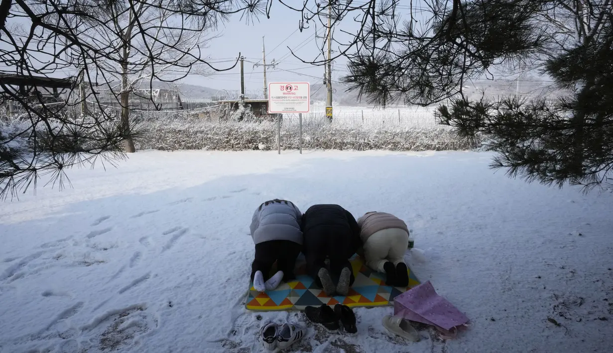 Pengungsi Korea Utara dan anggota keluarganya memberikan penghormatan kepada leluhur mereka untuk merayakan tahun Baru Imlek saat mengunjungi Paviliun Imjingak dekat perbatasan dengan Korea Utara, di Paju, Korea Selatan, Selasa (1/2/2022). (AP Photo/Ahn Young-joon)