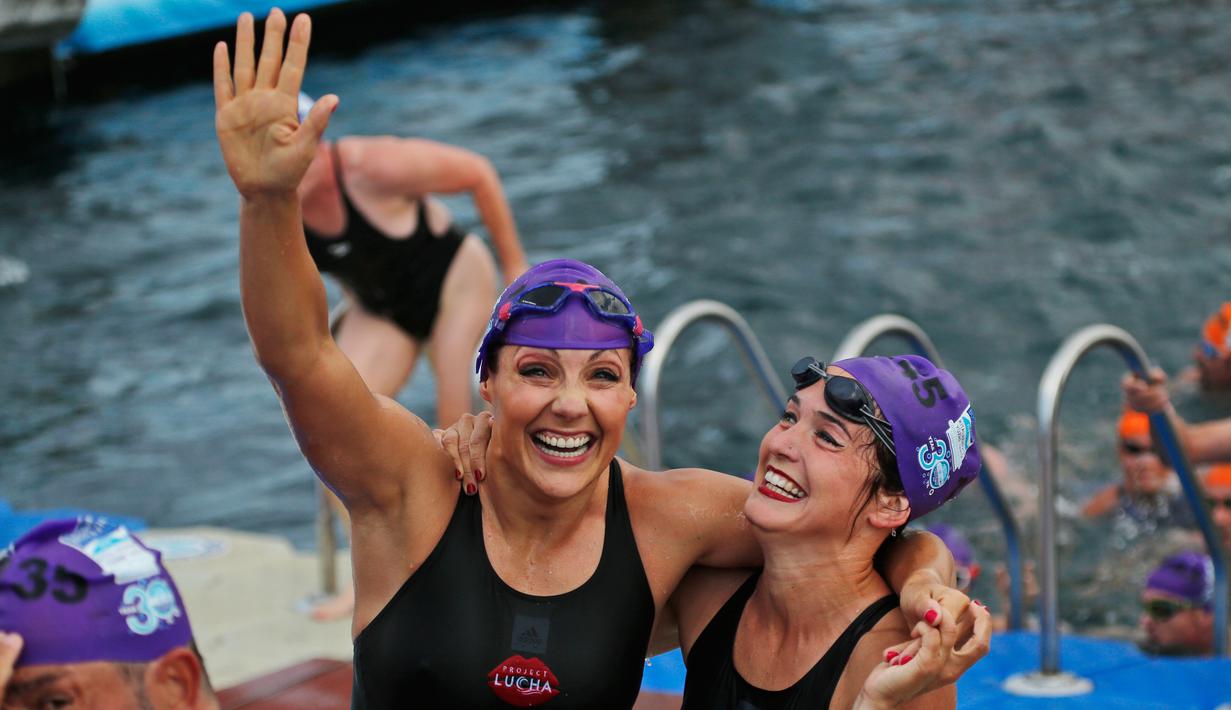 Ekspresi dua altet renang wanita setelah mengikuti lomba renang dari Asia hingga Eropa di Selat Bosphorus ke-30, Istanbul, Turki, (22/7). (AP Photo/Lefteris Pitarakis)