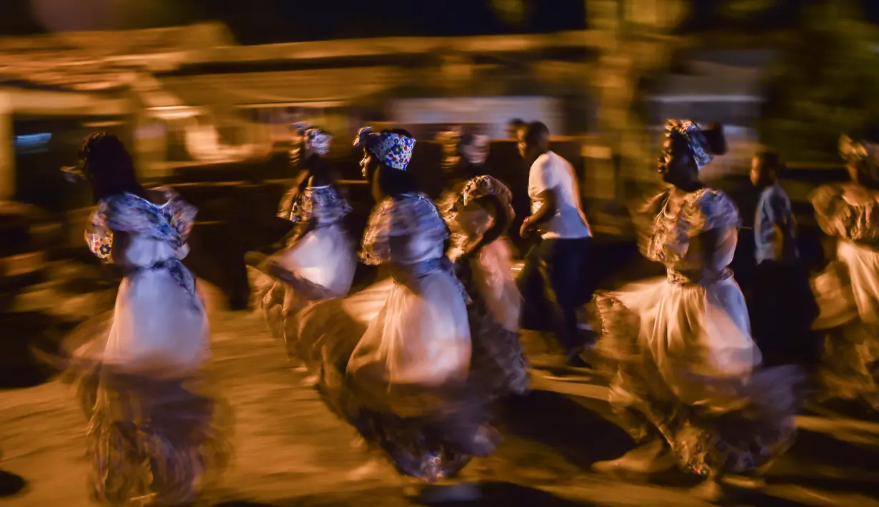 Sejumlah orang menari tarian tradisional Fuga saat perayaan "Adoraciones al Nino Dios" di Quinamayo, Kolombia (18/2). Perayaan Natal ini tidak digelar pada bulan Desember, melainkan digelar setiap bulan Februari. (AFP Photo/Luis Robayo)