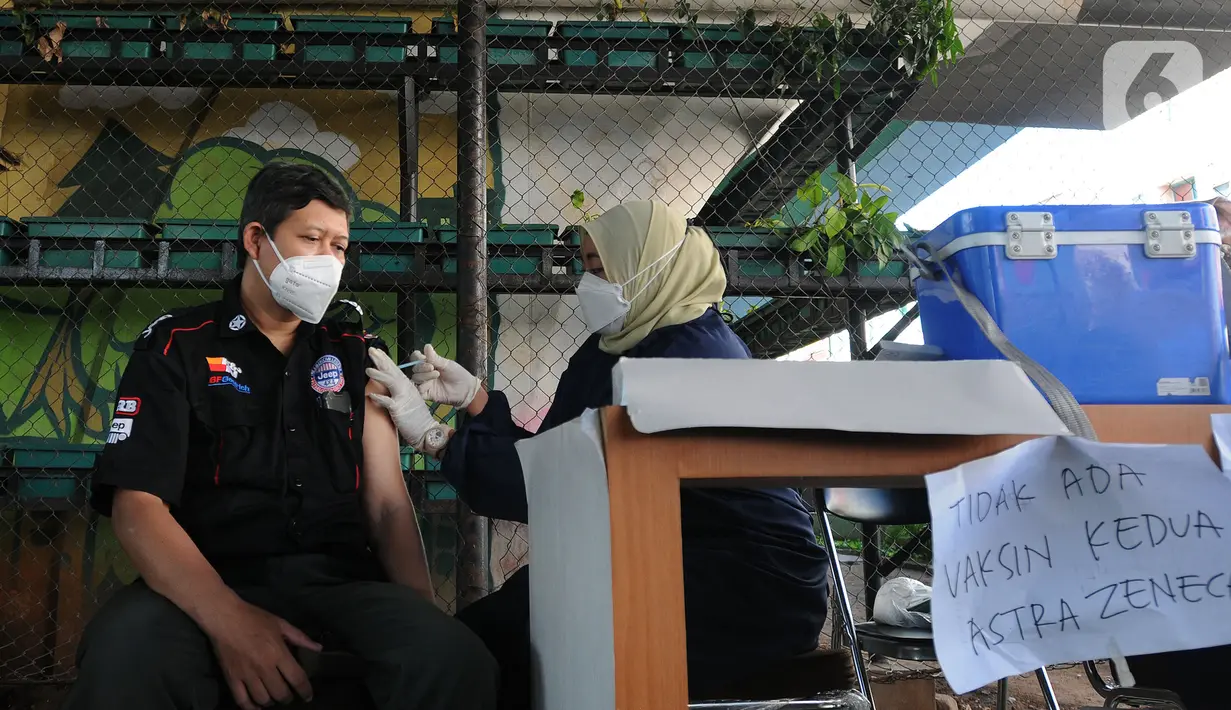 Vaksinator menyuntikkan vaksin dosis ketiga kepada seorang pria di kolong flyover Ciputat, Tangerang Selatan, Sabtu (2/4/2022). Vaksinasi booster tersebut diselenggarakan oleh Polsek Ciputat Timur dan Polres Tangerang Selatan. (merdeka.com/Arie Basuki)