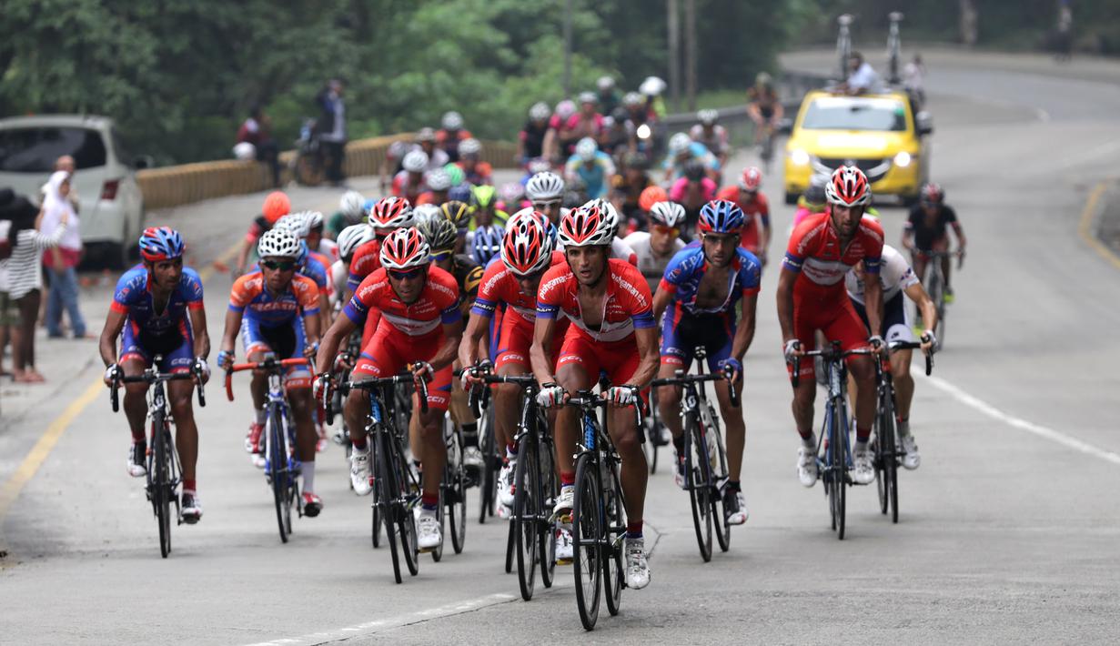 Pebalap Pishgaman Giant Team (kaos merah) memimpin rombongan saat melewati tanjakan Panorama dalam Etape 2 Tour de Singkarak 2015, Minggu (4/10/2015). (Bola.com/Arief Bagus)