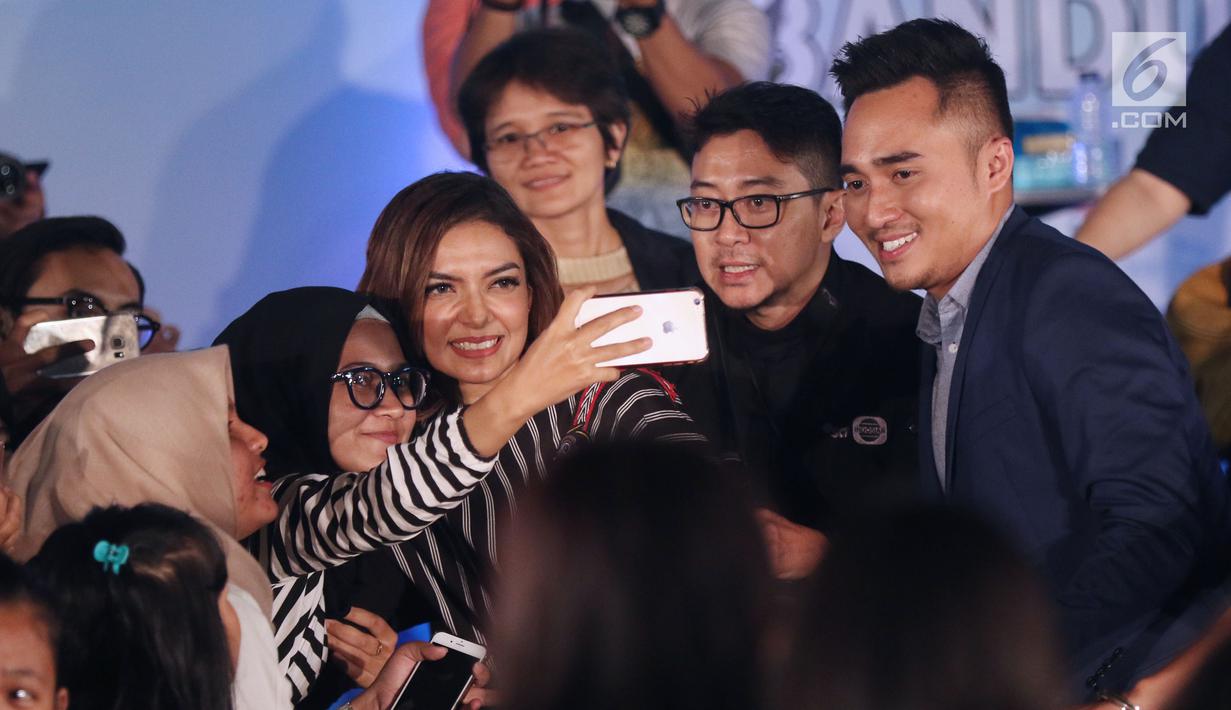 Duta baca Indonesia, Najwa Shihab (tengah) berswafoto dengan peserta acara Emtek Goes To Campus (EGTC) 2017 di Universitas Telkom, Bandung, Rabu (29/11). (Liputan6.com/Helmi Fithriansyah)