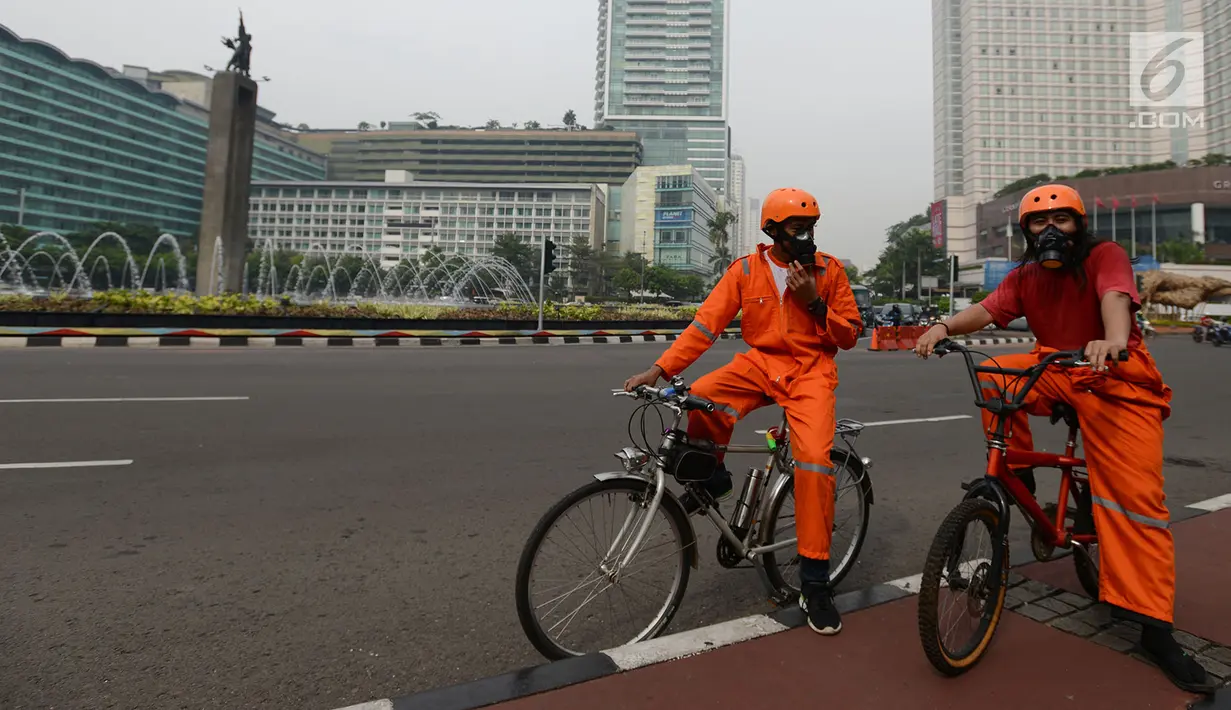 Aktivis melakukan kampanye damai terkait buruknya udara Jakarta di Bundaran HI, Rabu (5/12). Dalam aksinya, mereka juga mengajak warga untuk menggunakan sepeda sebagai cara menekan tingkat polusi udara. (Merdeka.com/Imam Buhori)