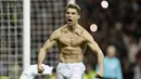 Striker Real Madrid, Cristiano Ronaldo, melakukan selebrasi pamer otot usai mencetak gol ke gawang Juventus pada laga Liga Champions di Stadion Santiago Bernabeu, Rabu (11/4/2018). Real Madrid takluk 1-3 dari Juventus. (AFP/Oscar Del Pozo)