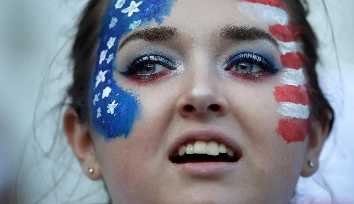 Fans wanita melukis bendera AS di wajahnya sebelum pertandingan Grup F Piala Dunia Wanita 2019 antara Amerika Serikat melawan Thailand di Stadion Auguste-Delaune di Reims, Prancis (11/6/2019). (AP Photo/Alessandra Tarantino)