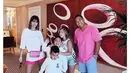 Tampil kompak bareng keluarga dengan outfit nuansa pink, Nia Ramadhani tampak mengenakan white t-shirt, hot pants pink, dan waist bag. (Instagram/ramadhaniabakrie).