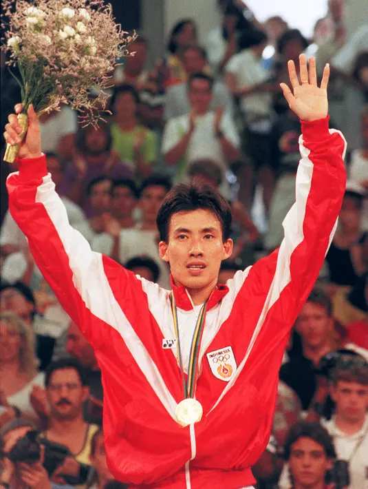 Pemain badminton Indonesia Alan Budikusuma berdiri di podium usai mengalahkan pemain badminton Denmark T.S. Lauridsen pada pertandingan final tunggal putra Olimpiade Barcelona 1992 di Barcelona, Spanyol, 4 Agustus 1992. Alan Budikusuma berhasil membawa pulang medali emas. (ALBERTO MARTIN/AFP)