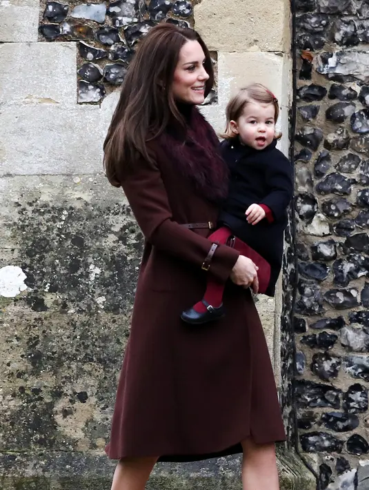 Duchess of Cambridge, Kate Middleton menggendong Putri Charlotte untuk mengikuti Misa Natal di Gereja St Mark, Englefield, Inggris, Minggu (25/12). Putri Charlotte tampak stylish menggunakan coat biru dengan legging merah. (REUTERS/Andrew Matthews/Pool)