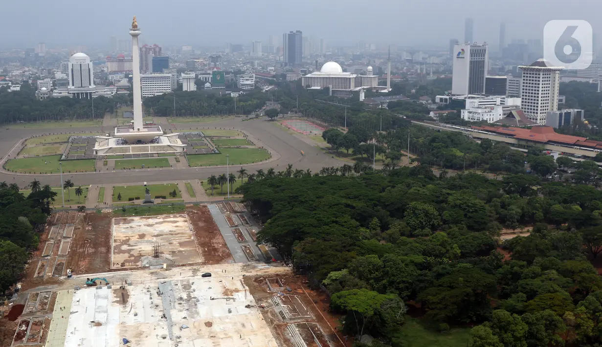 Aktivitas pengerjaan proyek revitalisasi Taman Sisi Selatan Monumen Nasional dilihat dari ketinggian, Jakarta, Minggu (19/1/2020). Proses revitalisasi dimulai dengan penebangan ratusan pohon di taman selatan Monas dan menjadikan kawasan tersebut terlihat gersang. (Liputan6.com/Helmi Fithriansyah)