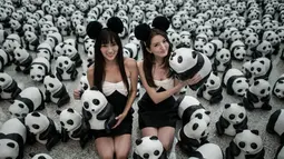 Para model berkostum hitam putih tampak berfoto dengan ribuan panda di Bandara Internasional Hong Kong, Senin (9/6/14). (AFP PHOTO/Philippe Lopez)