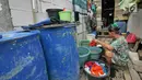 Warga mencuci pakaian di kawasan Kampung Kamal Muara, Jakarta, Selasa (9/7/2019). Saat musim kemarau, warga Kampung Kamal Muara harus membeli air seharga Rp 5.000 per jeriken untuk kebutuhan mandi, cuci pakaian dan lain-lain. (Liputan6.com/Herman Zakharia)