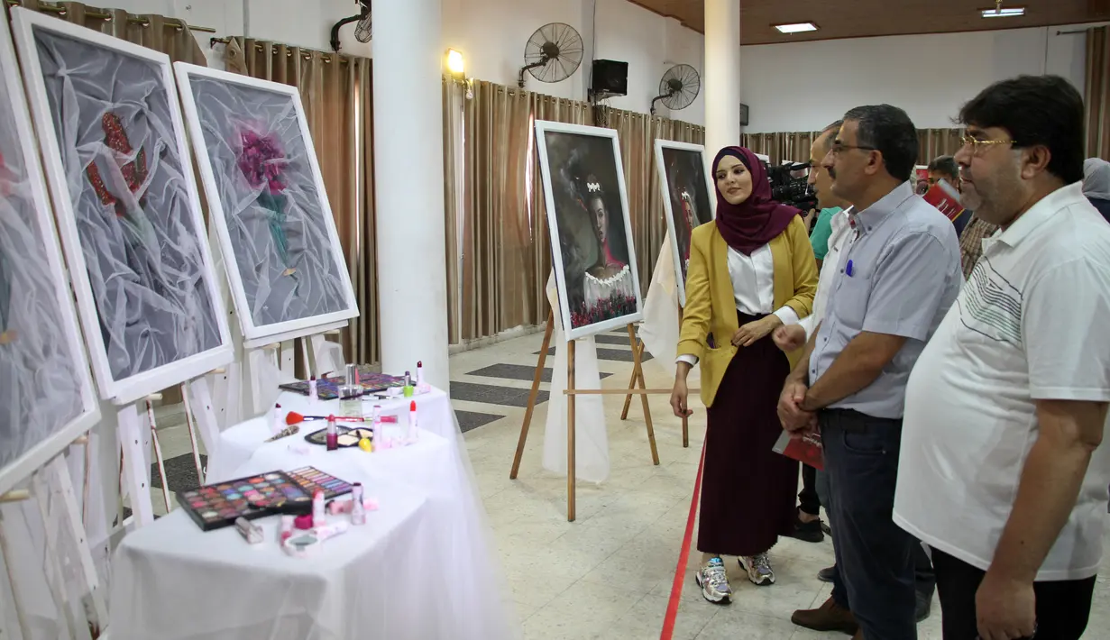 Orang-orang mengunjungi pameran seniman Palestina Kholoud al-Dasooqi di Gaza City, 11 Agustus 2020. Seniman Palestina asal Kota Khan Younis di Jalur Gaza itu menggelar pameran selama dua hari untuk mengungkap kekerasan terhadap perempuan melalui puluhan lukisan. (Xinhua/Rizek Abdeljawad)