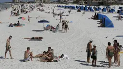 Pengunjung menikmati Clearwater Beach di Florida, Amerika Serikat, Rabu (18/3/2020). Virus corona COVID-19 sudah menyebar ke seluruh wilayah Amerika Serikat dengan jumlah kasus sebanyak 5.359 dan menewaskan 100 orang. (AP Photo/Chris O'Meara)