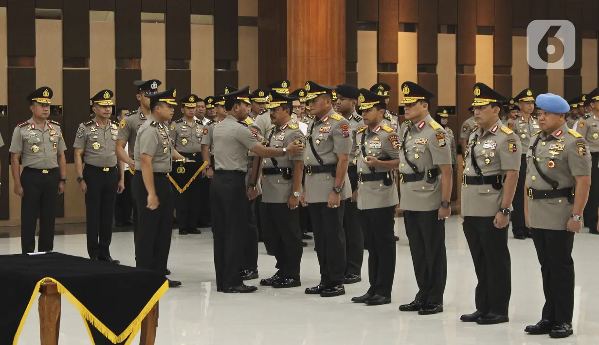 Kapolri Jenderal Pol Idham Azis saat memasangkan lencana kepada sejumlah perwira saat serah terima jabatan  di Mabes Polri Jakarta, Senin (16/12/2019). Komisaris Jenderal Firli Bahuri dari jabatan semula Kepala Baharkam Polri menjadi Analis Kebijakan Baharkam Polri. (Liputan6.com/Johan Tallo)