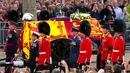 Band Coldstream Guards tampil saat prosesi Ratu Elizabeth II di London, Inggris, 14 September 2022. Warga berada di kanan-kiri jalan untuk menyaksikan keberangkatan peti jenazah Ratu Elizabeth II dari Istana Buckingham yang telah menjadi rumahnya sebagai ratu selama 70 tahun terakhir. (Nathan Denette/The Canadian Press via AP)