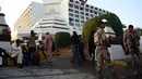 Petugas berjaga di lokasi kebakaran sebuah hotel mewah di kota Karachi, Pakistan, Senin (5/12). Wali Kota Karachi Waseem Akhtar mengatakan penyebab kebakaran ini masih belum diketahui secara pasti. (RIZWAN Tabassum/AFP)