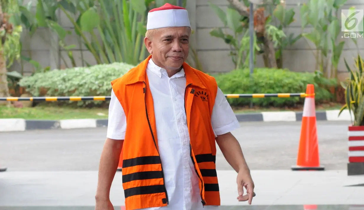Gubernur nonaktif Aceh Irwandi Yusuf tersenyum saat tiba di Gedung KPK, Jakarta, Jumat (24/8). Irwandi Yusuf datang dengan mengenakan kopiah merah putih dan sepatu sport. (Merdeka.com/Dwi Narwoko)