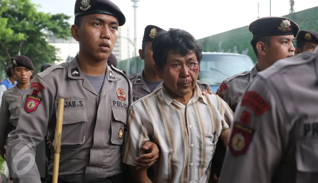 Seorang pengemudi Go-Jek bernama Siswanto (tengah) menjadi korban dari amukan oknum sopir taksi yang berada di dekat gedung TVRI Senayan, Jakarta, (22/3).Pria ini mengaku dihadang dan dipukuli oleh sejumlah pengemudi taksi. (Liputan6.com/Herman Zakharia)