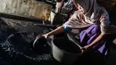 Pekerja menumbuk biji kopi setelah melalui proses pemanggangan tradisional di sebuah pabrik di Banda Aceh, Aceh, Rabu (3/3). (CHAIDEER MAHYUDDIN/AFP)