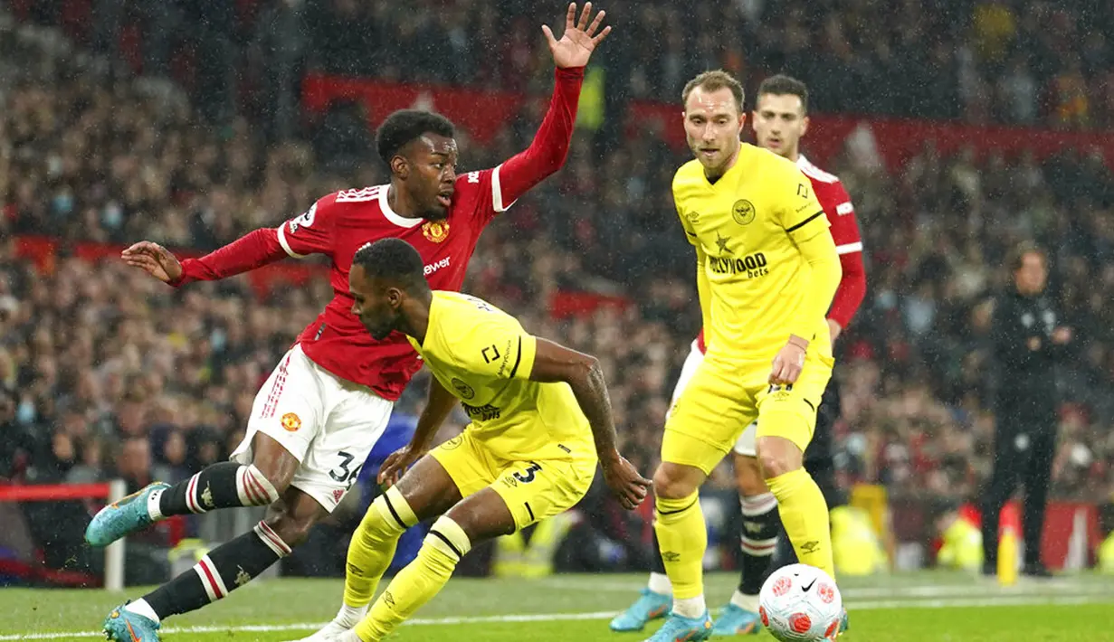 <p>Pemain Manchester United Anthony Elanga (kiri) berebut bola dengan pemain Brentford Rico Henryc pada pertandingan sepak bola Liga Inggris di Stadion Old Trafford, Manchester, Inggris, 2 Mei 2022. Manchester United menang 3-0. (AP Photo/Jon Super)</p>