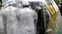 Umat ​​muslim berlindung di bawah lembaran plastik saat melaksanakan sholat Idul Adha pada pagi hari yang diguyur hujan di Mumbai, India, Kamis (29/6/2023). (Photo by INDRANIL MUKHERJEE / AFP)