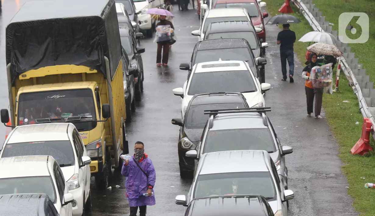 Sejumlah pedagang asongan menawarkan dagangan kepada pengendara di jalan tol Jagorawi yang sedang menanti waktu buka tutup jalur menuju kawasan wisata puncak, Bogor, Jawa Barat, Sabtu (31/10/2020). (Liputan6.com/Helmi Fithriansyah)