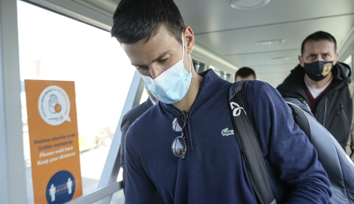 Petenis Serbia Novak Djokovic melihat dokumennya setelah mendarat di Beograd, Senin (17/1/2022). Djokovic tiba di ibu kota Serbia setelah dideportasi Australia usai kalah dalam upaya tinggal di negara itu untuk mempertahankan gelar Australia Terbuka meskipun tidak divaksinasi (AP Photo/Darko Bandic)