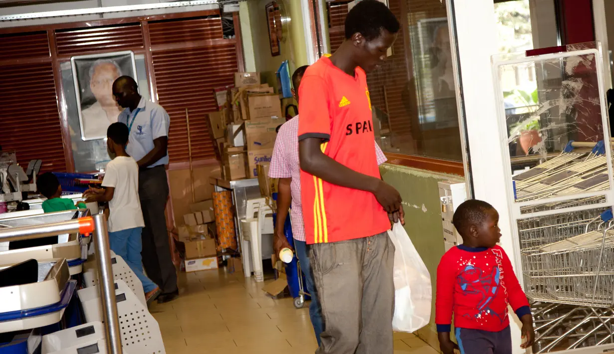 Seorang pelanggan membawa kantong kain belanjaan miliknya di Nairobi, Kenya, Senin (28/8). Larangan penggunaan, pembuatan, serta impor kantong plastik diberlakukan setelah Pengadilan Tinggi Kenya mengeluarkan keputusannya. (AP Photo/Sayyid Abdul Azim)