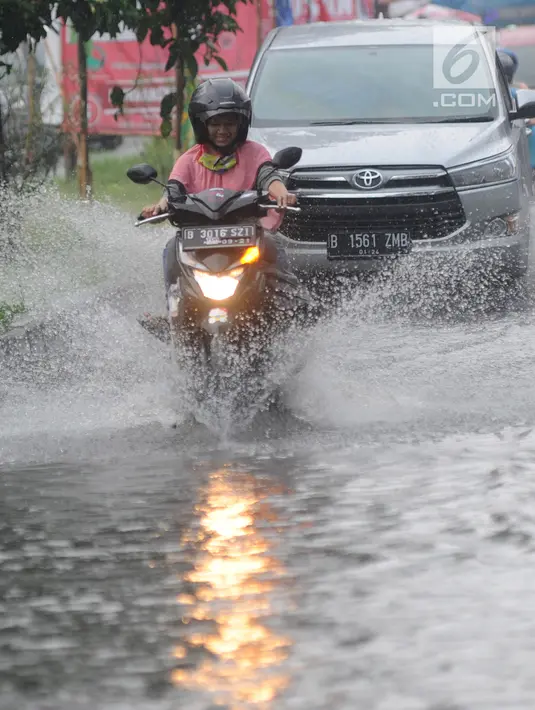 Pengendara bermotor melewati banjir di Jalan Cinere Raya (depan Mall Cinere), Depok, Jawa Barat, Minggu (31/3). Banjir terjadi akibat sistem drainase yang buruk. (merdeka.com/Arie Basuki)