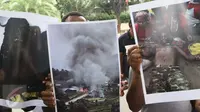 Mahasiswa membawa poster yang menggambarkan korban akibat konflik saat menggelar aksi di Gedung Komisi Pemilihan Umum (KPU) Pusat, Jakarta, Selasa (14/3). (Liputan6.com/Helmi Afandi)