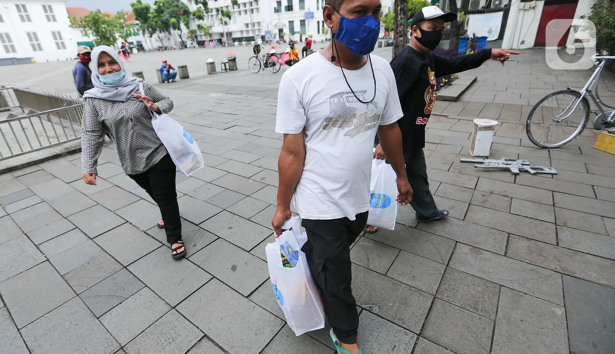 Warga menerima paket sembako usai acara kegiatan CSR Tiket Ramadan di Kota Tua Fatahillah, Jakarta, Kamis (06/05/2021). Kegiatan sosial bertajuk Beramal Bersama Teman menjelang Idul Fitri juga digelar di Yogyakarta dan Bali. (Liputan6.com/Fery Pradolo)