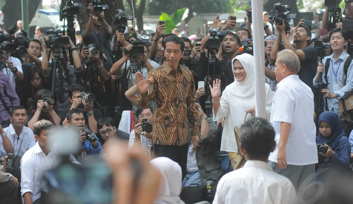 Jokowi bersama istri, Iriana menggunakan hak suaranya di TPS 18 Kecamatan Menteng, Jakarta, Rabu (9/7/14). (Liputan6.com/Herman Zakharia)