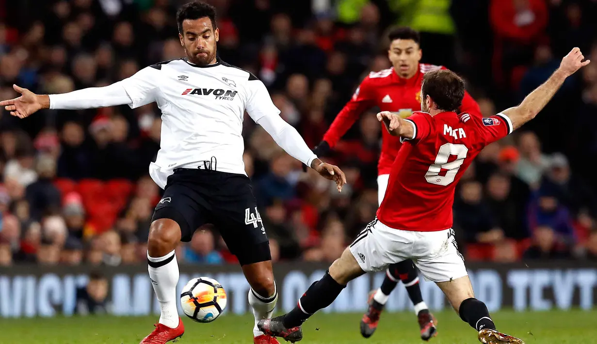 Gelandang Manchester United, Juan Mata berebut bola dengan pemain Derby County, Tom Huddleston saat bertanding pada babak tiga Piala FA di Old Trafford, Inggris (5/1). MU menang 2-0 atas Derby County. (Martin Rickett/PA via AP)