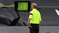 Wasit Mike Dean, memeriksa VAR atas gol yang dicetak gelandang Manchester City, Aymeric Laporte dalam laga lanjutan Liga Inggris pekan ke-9 melawan Totenham Hotspur di Tottenham Hotspur Stadium, London, Minggu (22/11/2020) dini hari WIB. City kalah 0-2 dari Tottenham. (AFP/Neil Hall/Pool)