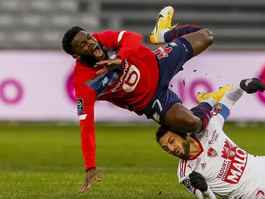 Striker Lille, Jonathan Bamba (atas) terjatuh ditekel gelandang Brest, Paul Lasne dalam laga lanjutan Liga Prancis 2020/21 pekan ke-25 di The Stade Pierre Mauroy, Lille, Minggu (14/2/2021). Lille bermain imbang 0-0 dengan Brest. (AP/Michel Spingler)