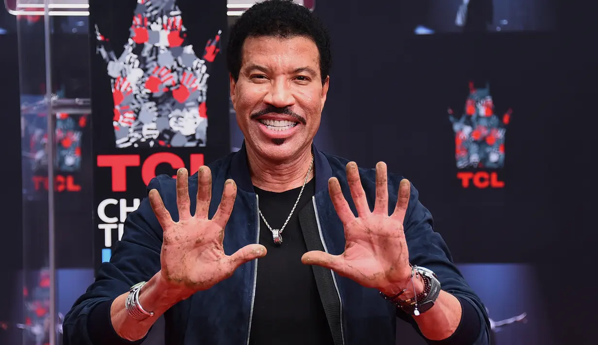 Lionel Richie menunjukkan telapak tangannya yang masih berlumuran semen di TCL Chinese Theatre, Hollywood, Rabu (7/3). Selama enam dekade aktif dalam dunia musik, Richie sukses menjual 100 juta album di seluruh dunia. (Jordan Strauss/Invision/AP)