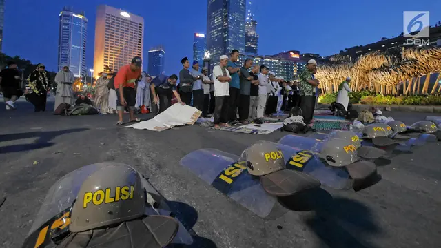 Massa Melaksanakan Salat Magrib di Kawasan Bundaran HI Jakarta
