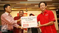 Direktur Utama PT Sido Muncul Irwan Hidayat (kanan) memberikan bantuan secara simbolis kepada Kusrin di Jakarta, Jumat (5/2). Sido Muncul meluncurkan iklan terbaru Kuku Bima Energi versi 'Kusrin'. (Liputan6.com/Immanuel Antonius)