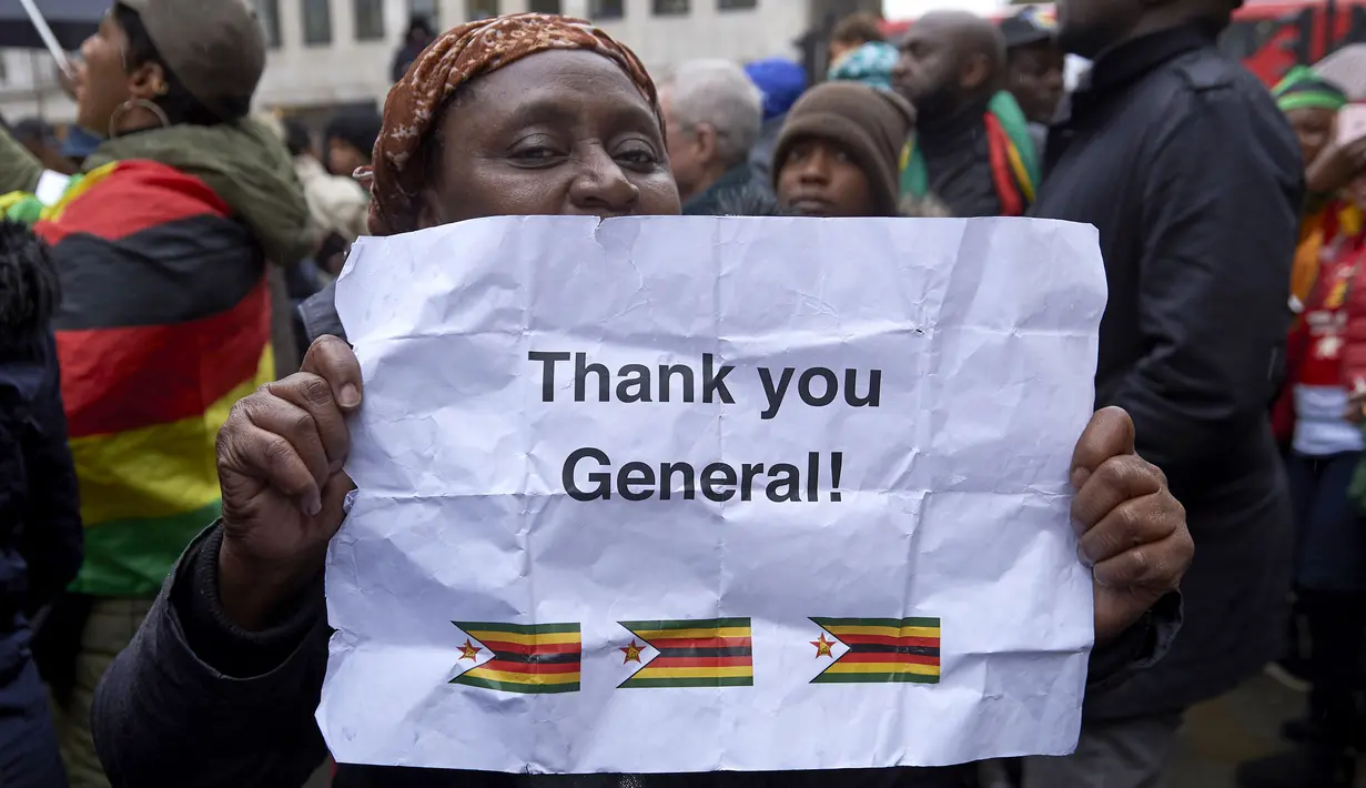 Demonstran memegang kertas bertuliskan "Thank You General" dalam aksi protes di luar Kedutaan Besar Zimbabwe di London, Sabtu (18/11). Warga Zimbabwe yang menetap di Inggris berkumpul mendukung runtuhnya rezim Presiden Robert Mugabe. (NIKLAS HALLE'N/AFP)