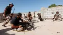 Pasukan militer pemerintah Libya mempersiapkan sejumlah senjata api saat melakukan serangan kepada para pejuang ISIS dari atap atap rumah di daerah Zaafran, di Sirte, Libya, 30 Juni 2016. (REUTERS/Ismail Zitouni)