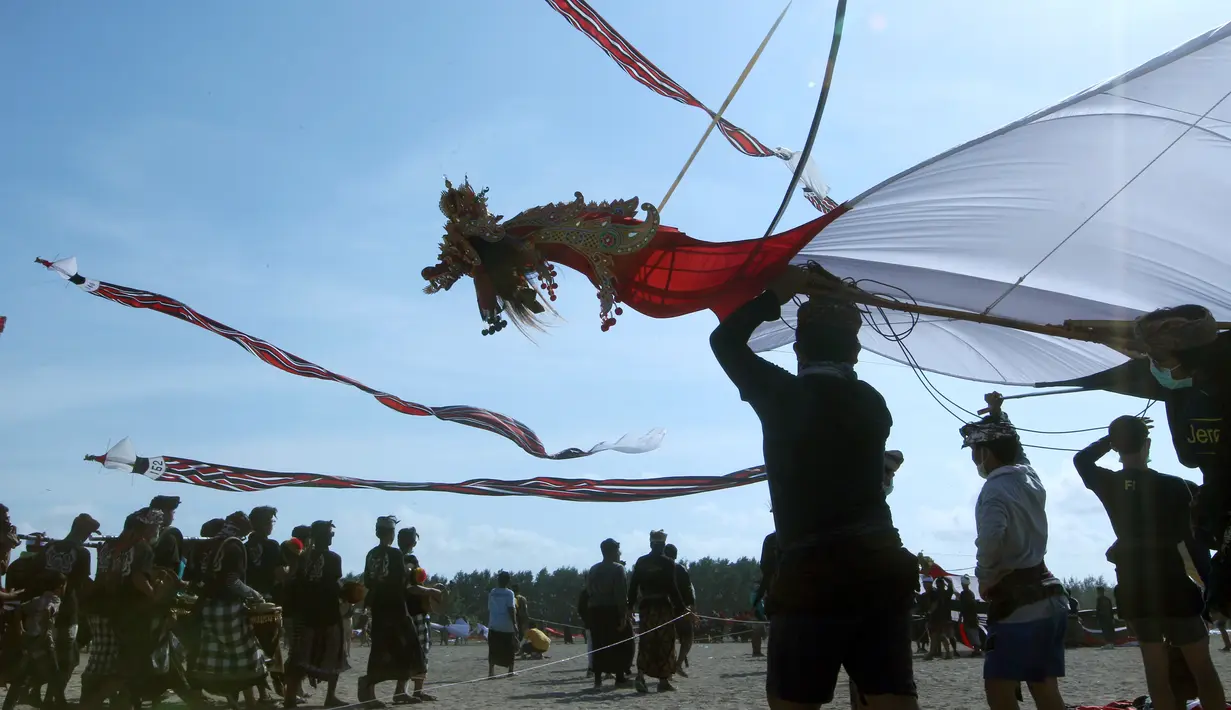 Pria Bali saat menerbangkan layang-layangnya saat mengikuti lomba layang-layang tradisional dalam festival layang-layang di Bali, Indonesia, (6/8). Festival ini diselenggarakan untuk mempromosikan pariwisata di pulau resor. (AP Photo/Firdia Lisnawati)