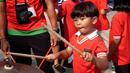 Seorang pendukung cilik Indonesia memukul simbal drum saat menunggu laga kedua Grup A Sepak Bola SEA Games 2023 antara Timnas Indonesia melawan Timnas Myanmar di Olympic Stadium, Phnom Penh, Kamboja, Kamis (04/05/2023). Skuad asuhan Indra Sjafri tersebut berhasil menang dengan skor telak 5-0. (Bola.com/Gregah Nurikhsani)