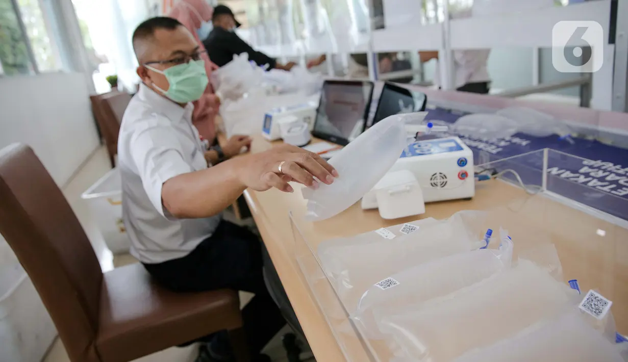 Petugas PT KAI (Persero) menata kantong alat tes deteksi COVID-19 dengan metode GeNose C19 di Stasiun Gambir, Jakarta, Rabu (24/3/2021). PT KAI (Persero) menaikkan tarif pemeriksaan tes GeNose C19 dari Rp20 ribu menjadi Rp30 ribu mulai 20 Maret 2021. (Liputan6.com/Faizal Fanani)