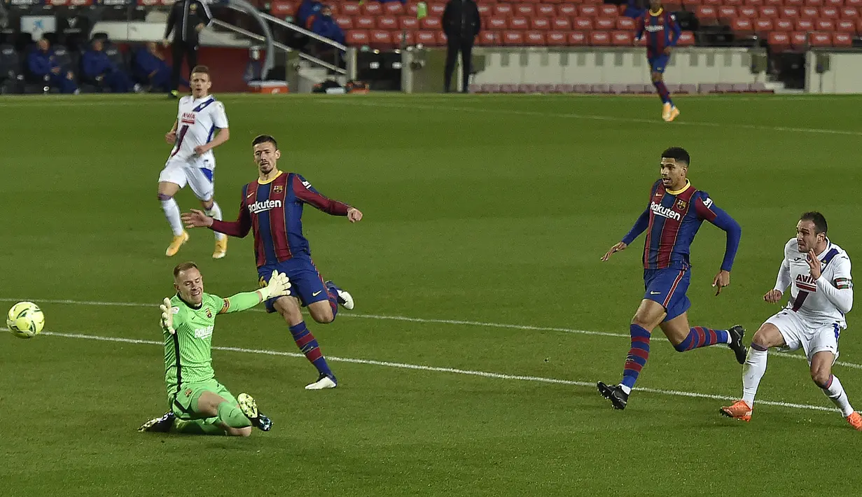 Striker Eibar, Kike Garcia (kanan) melepaskan tendangan yang gagal diantisipasi kiper Barcelona, Marc-Andre ter Stegen dalam laga lanjutan Liga Spanyol 2020/21 pekan ke-16 di Camp Nou, Selasa (29/12/2020). Eibar bermain imbang 1-1 dengan Barcelona. (AFP/Pau Barrena)