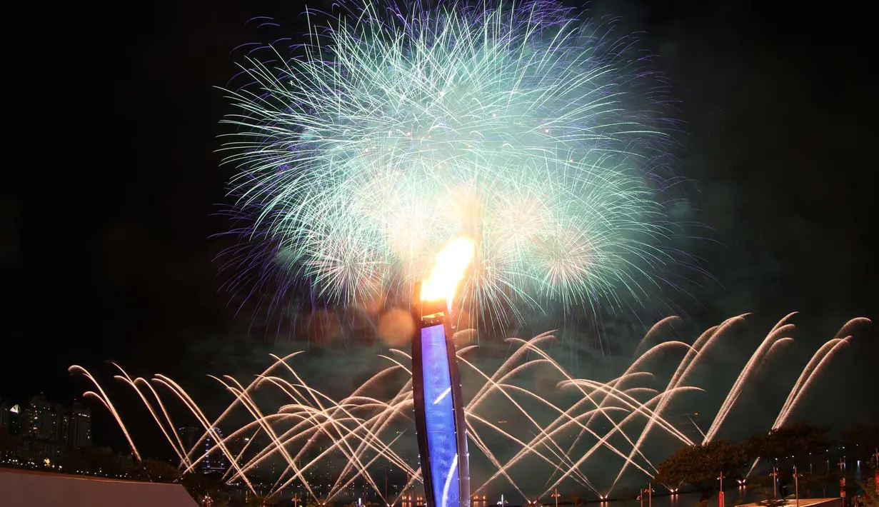 Pesta kembang api yang menjadi latar kaldron api SEA Games menghiasi langit Singapura pada saat Pembukaan SEA Games 2015 di Stadion Nasional Singapura. Jumat (5/6). (Bola.com/Arief Bagus)