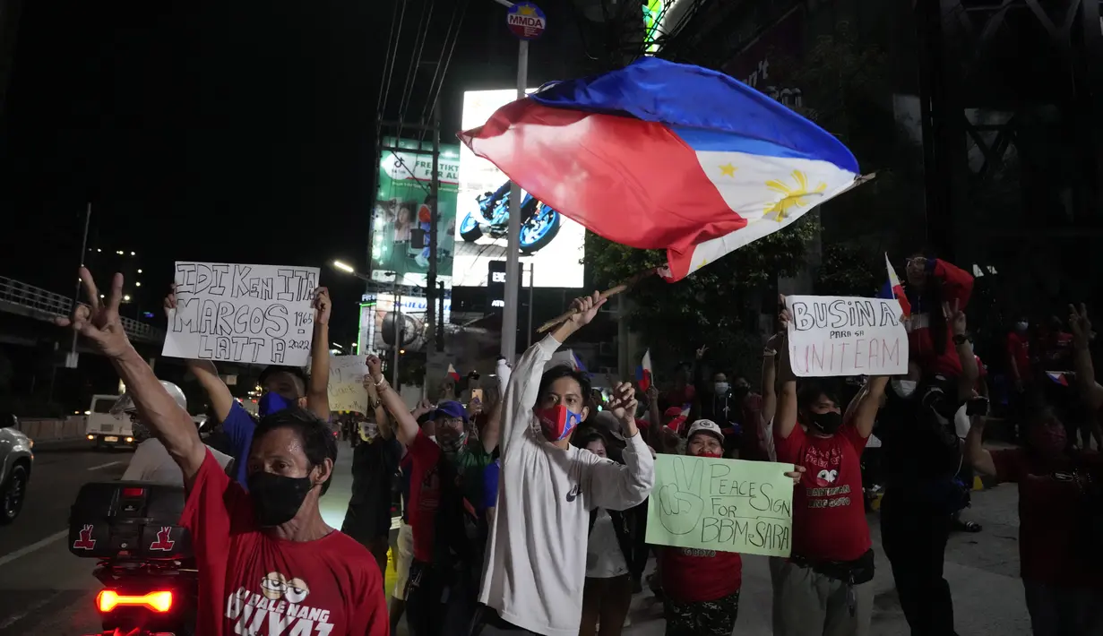 <p>Para pendukung melintas saat mereka tiba di markas Ferdinand "Bongbong" Marcos Jr di Mandaluyong, Filipina pada Senin malam (9/5/2022). Ferdinand Marcos Jr., putra mendiang Ferdinand Marcos, diktator Filipina yang terguling, jauh memimpin dalam penghitungan suara tidak resmi pemilu presiden hari Senin. (AP Photo/Aaron Favila)</p>