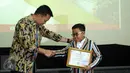 Menpora Imam Nahrawi menyerahkan penghargaan kepada Jefri Setiawan yang berhasil mencatat rekor dunia baru di Auditorium Kemenpora, Jakarta, Kamis (14/11). (Liputan6.com/Helmi Fithriansyah)