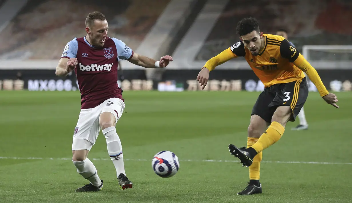 Bek Wolverhampton Wanderers, Rayan Ait-Nouri menendang bola di depan bek Vladimir Coufal dalam laga Liga Inggris pekan ke-30 di Molineux Stadium, Selasa (6/4/2021) dini hari WIB. West Ham menang 3-2 saat berlaga di kandang Wolverhampton. (Nick Potts/ Pool via AP)