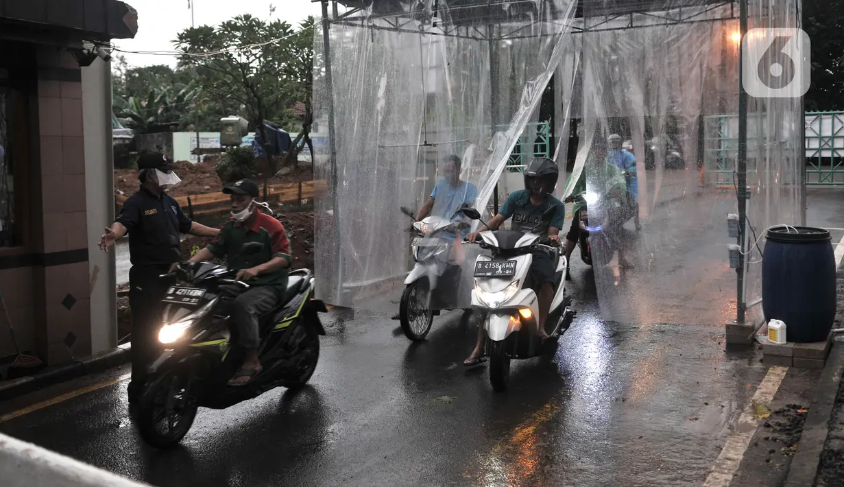 Pengendara sepeda motor keluar dari bilik penyemprotan disinfektan di pintu masuk Perumahan Tamansari Persada Raya, Jatibening, Bekasi, Jawa Barat, Selasa (31/3/2020). Bilik disinfektan dipasang untuk mencegah penyebaran virus corona COVID-19 di area kompleks. (Iqbal S. Nugroho)