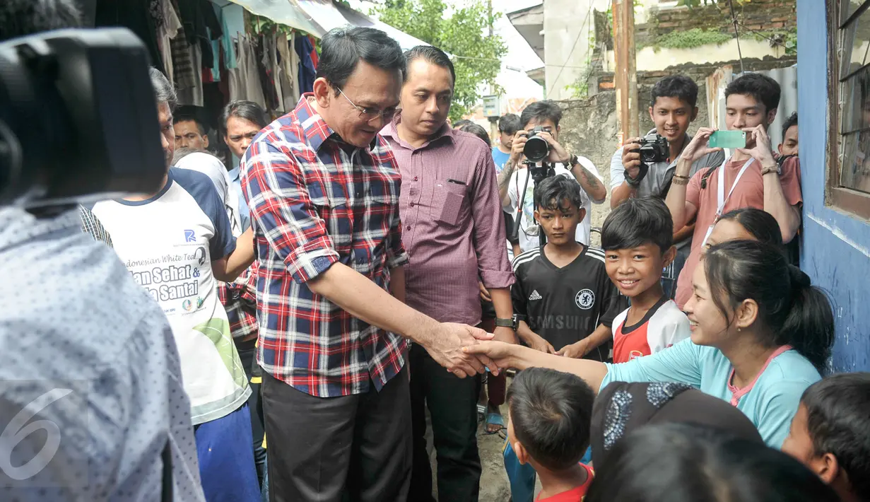 Cagub DKI Basuki Tjahaja Purnama ( Ahok ) menyapa warga saat blusukan ke wilayah Cililitan, Jakarta, Rabu (28/12). Dalam blusukannya tersebut Ahok mencari tahu permasalahan banjir di Cililitan Kecil. (Liputan6.com/Yoppy Renato)
